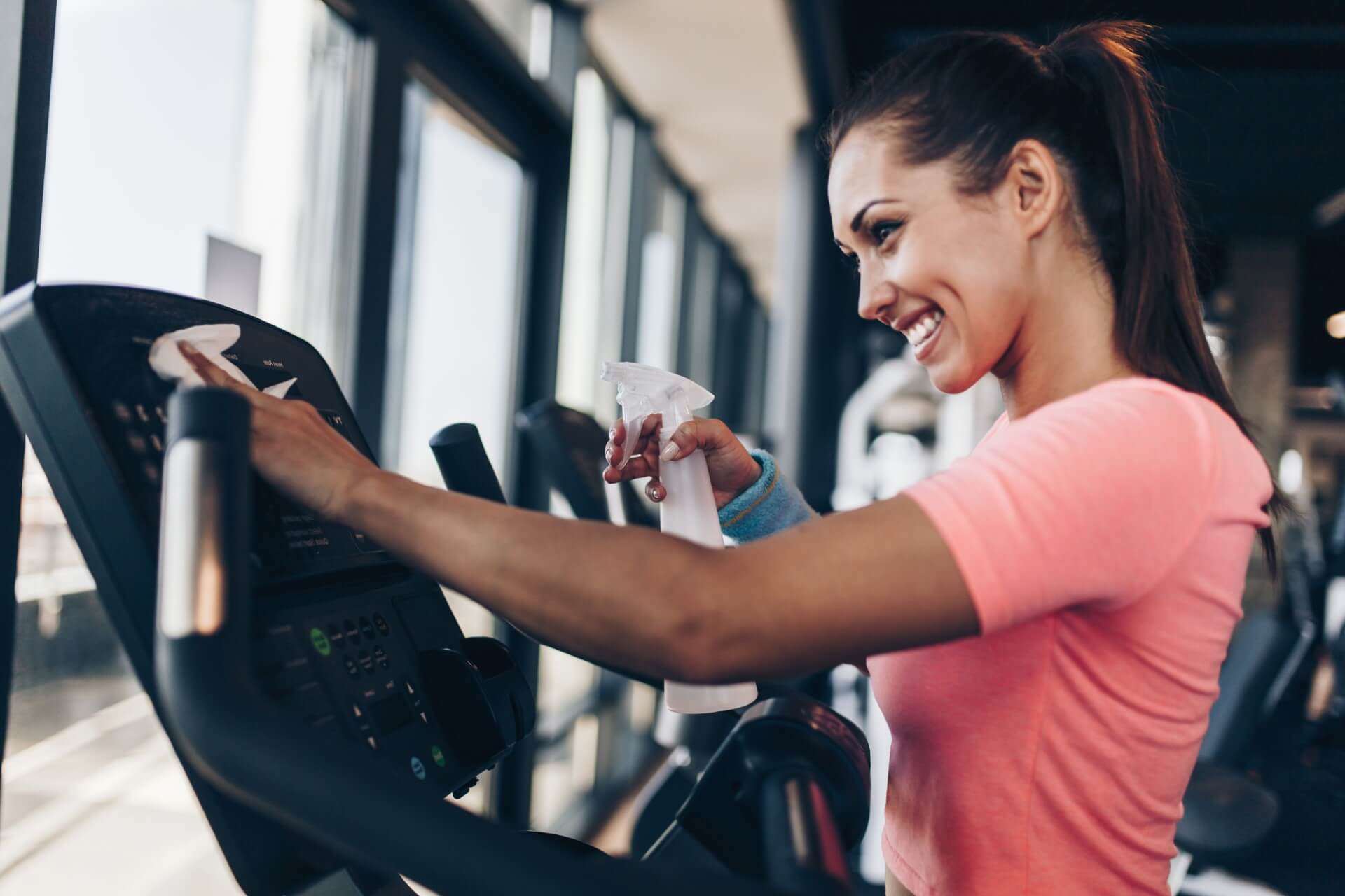 Eine Person reinigt ein Fitnessgerät